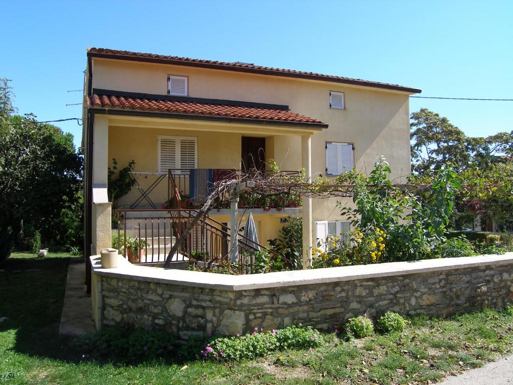 une maison avec un mur en pierre devant elle dans l'établissement Apartment Bolko - near the beach, à Banjole