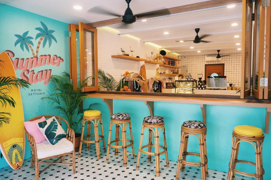 a bar with stools in front of a kitchen at Summer Stay Sattahip in Sattahip