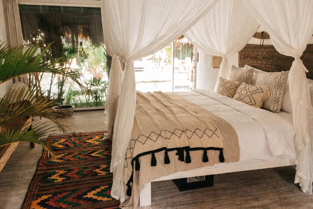 
a bedroom with a bed and a canopy at Dreamsea Canggu in Canggu
