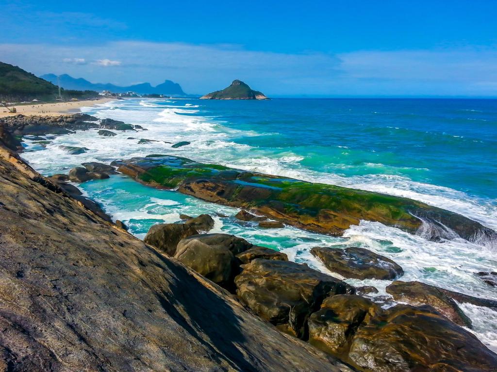 uma vista para o oceano a partir de uma praia rochosa em Casa em Condomínio no Rio de Janeiro
