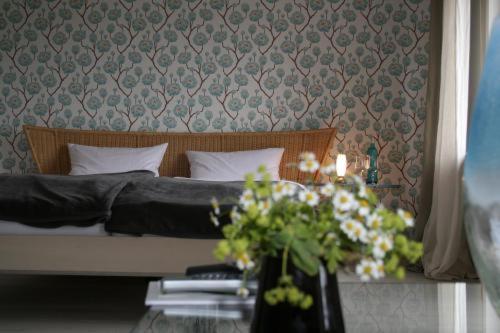 a bedroom with a bed and a table with flowers at Berghotel Wintersberg in Bad Ems