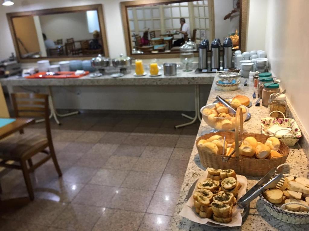 a buffet with a table with bread and pastries on it at Hotel Globo Rio in Sao Jose do Rio Preto