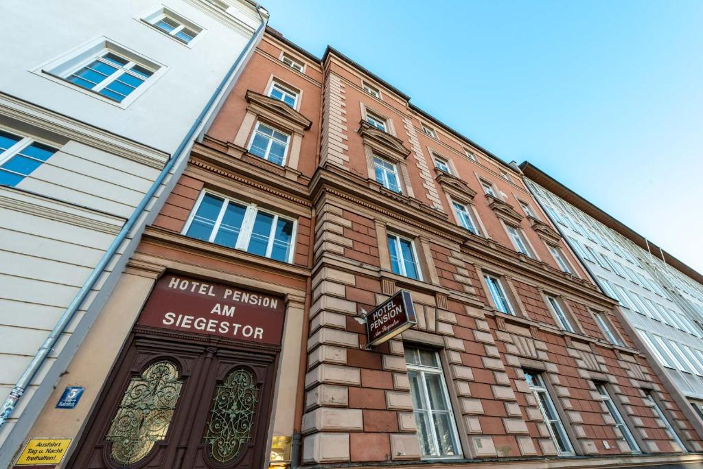 duży ceglany budynek z napisem w obiekcie Hotel-Pension am Siegestor w Monachium