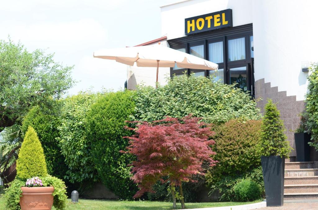 parasol przed hotelem z krzakami w obiekcie Hotel HDomus w mieście Nogarole Rocca