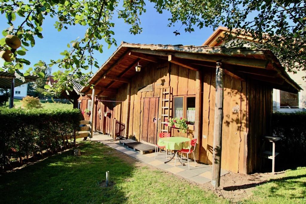 un pequeño cobertizo de madera con una mesa y una silla en Villa Kunterbunt, en Messkirch