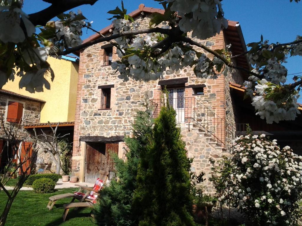 un bâtiment en pierre avec un arbre en face dans l'établissement Le Clos du Merle, à Savigny
