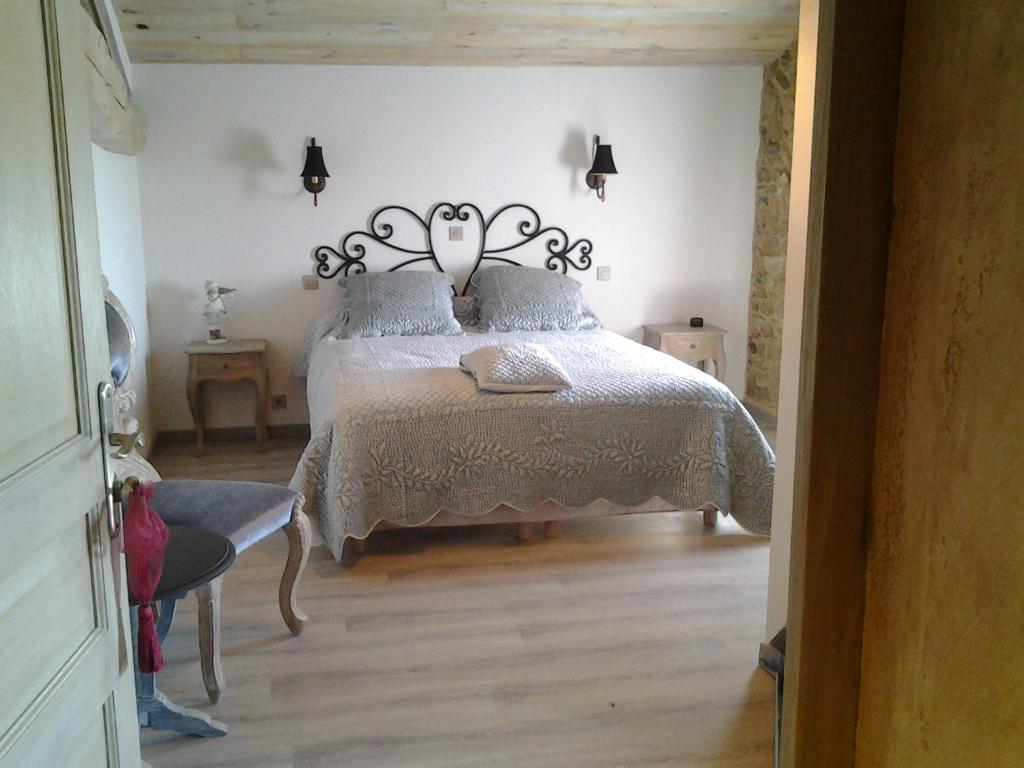 1 dormitorio con 1 cama con cabecero de metal en Le Clos du Merle, en Savigny