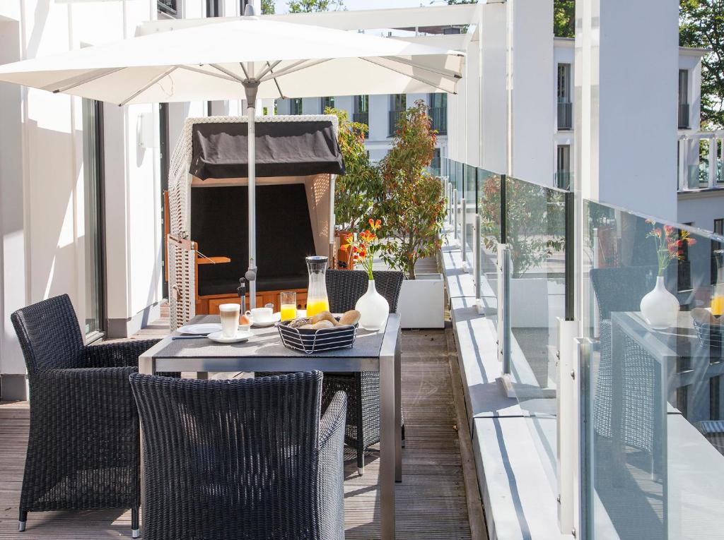 a table and chairs with an umbrella on a balcony at Beach Cloud***** in Binz