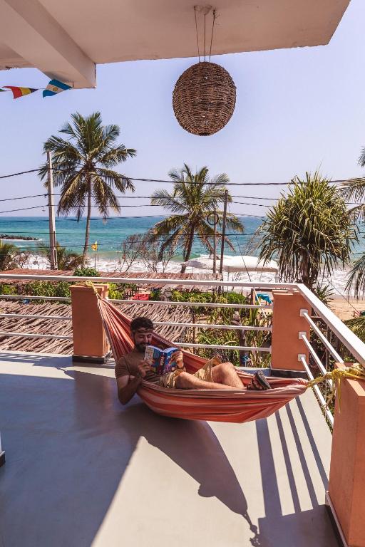 坦加拉Coppenrath Hostel的躺在海滩上的吊床上的人