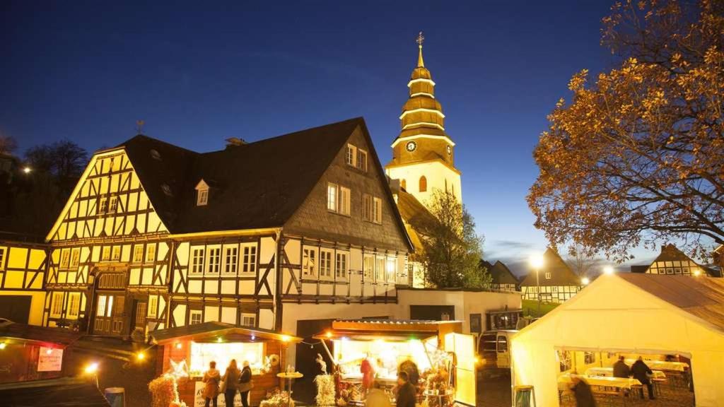 a large building with a clock tower in a town at night at Eversberg nahe Meschede in Meschede