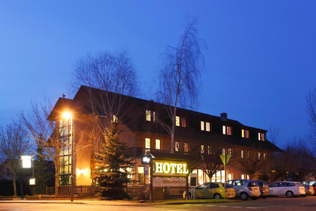 a building with a hotel with cars parked in a parking lot at Willmersdorfer Hof in Cottbus