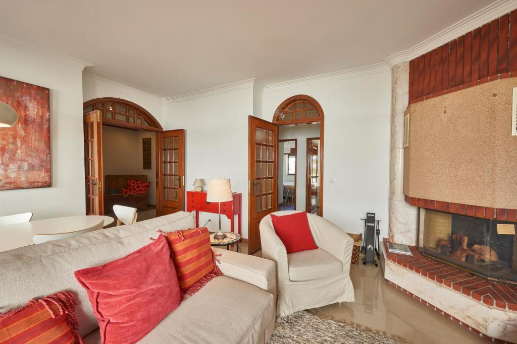 a living room with a couch and a fireplace at Cascais Handsome Apartment in Cascais