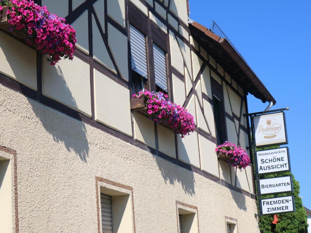 ein Gebäude mit Blumen auf der Seite in der Unterkunft Gasthaus Schöne Aussicht in Usingen