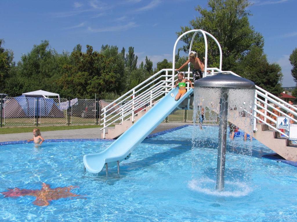 un grupo de niños jugando en un tobogán de agua en una piscina en NaturExpert Mobilházak-Füred Kemping Balatonfüred en Balatonfüred