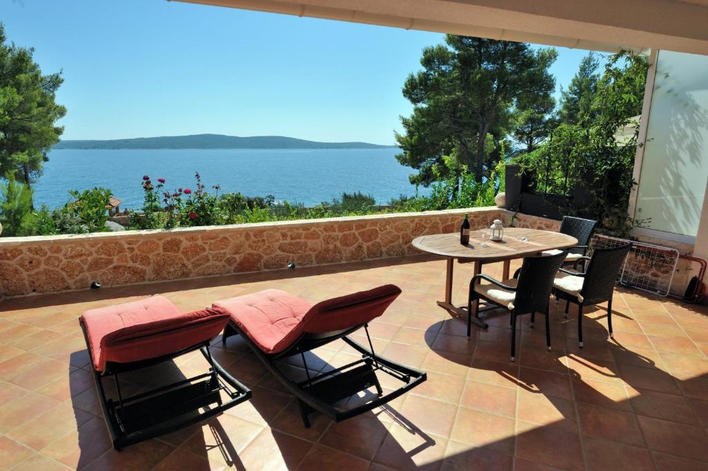 een patio met een tafel en stoelen en uitzicht op het water bij Nautilus-Bay Apartments - Seaview Apartments 210, 211 - Villa Gorma in Zavala