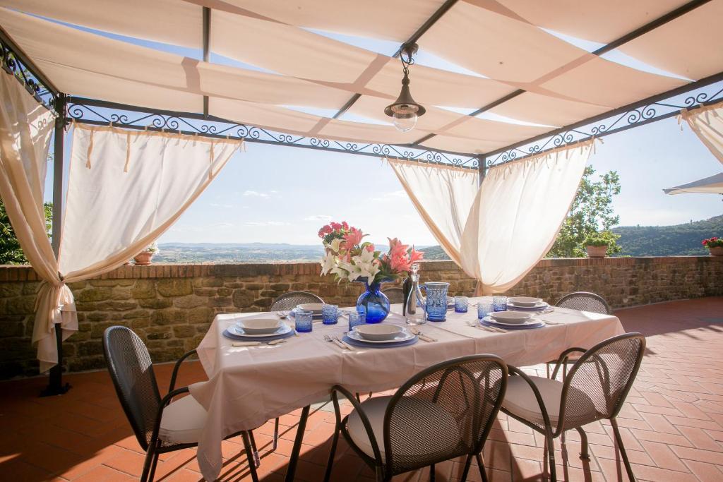 une table et des chaises sur une terrasse avec vue dans l'établissement Corte della Luna, à Cortone