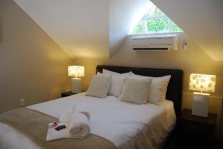 sypialnia z dużym białym łóżkiem i oknem w obiekcie The Lofts w mieście Polokwane