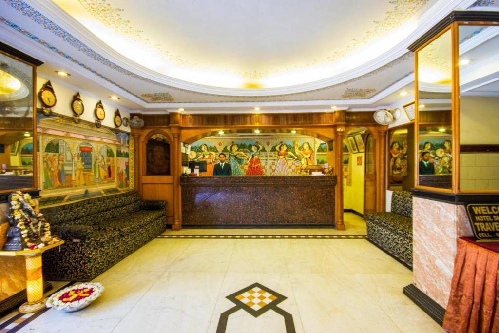 een kamer met schilderijen aan de muren en een eetkamer bij Hotel Shalimar in Jaipur