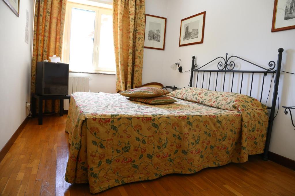 a bedroom with a bed with a blanket and a window at Tenuta Di Pietra Porzia in Frascati