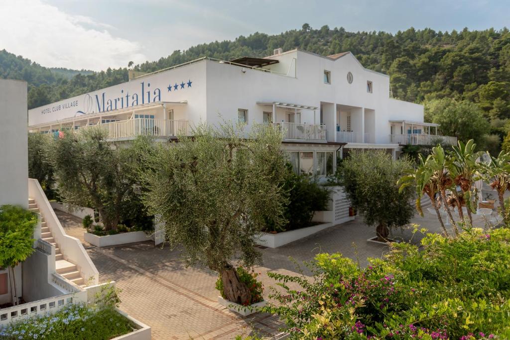 duży biały budynek z drzewami przed nim w obiekcie Hotel Club Village Maritalia w mieście Peschici