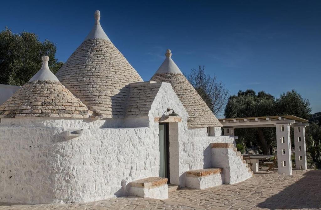 a white building with two towers and a gate at Mille e un Trullo in Ostuni