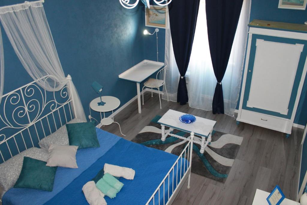 Dormitorio azul con cama y escritorio en Bed and Breakfast al Cucherle, en Trieste