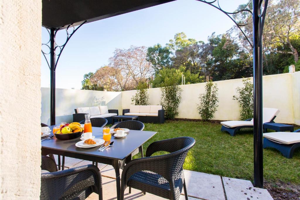 a patio with a table and chairs on a yard at ALTIDO Stunning 2BR Apt with garden, by the Avenida subway and Botanical Garden of Lisbon in Lisbon