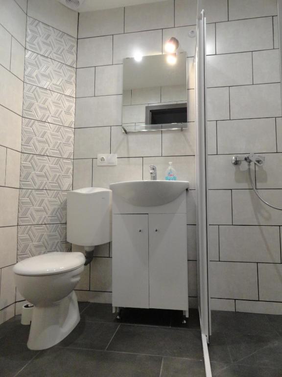 łazienka z toaletą i umywalką w obiekcie Trenta Apartman Bükfürdő w mieście Bük