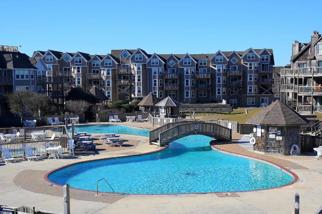 a swimming pool with a bridge and some buildings at Barrier Island Station in Duck