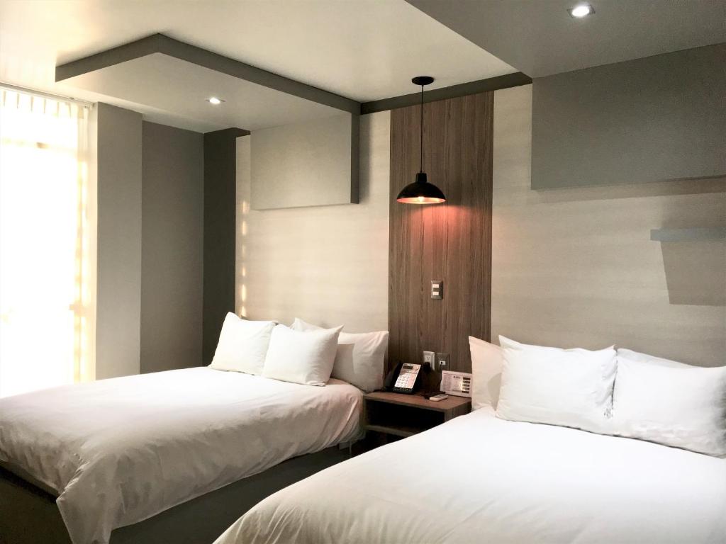 Postel nebo postele na pokoji v ubytování ESDUMA HK HOTEL Pachuca