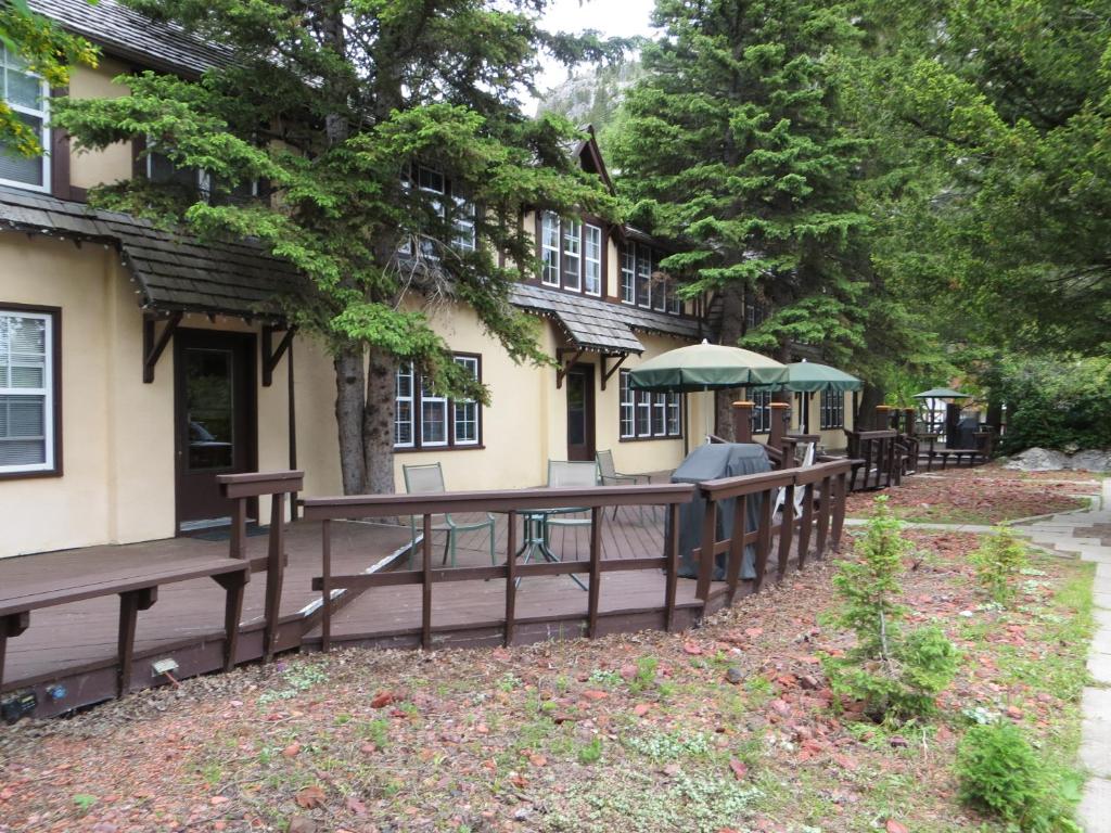 a building with benches and umbrellas in front of it at Crandell Mountain Lodge in Waterton Park