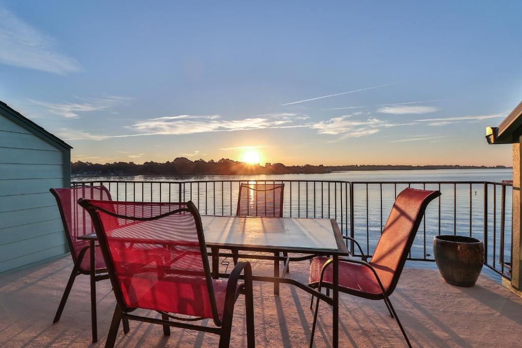 een tafel en stoelen op een terras met uitzicht op het water bij Resort Attractions in Willis
