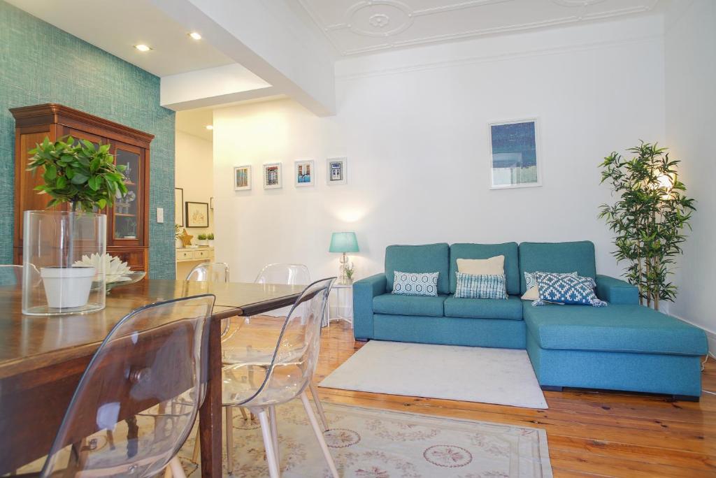 ein Wohnzimmer mit einem blauen Sofa und einem Tisch in der Unterkunft Lisbon City Center in Lissabon