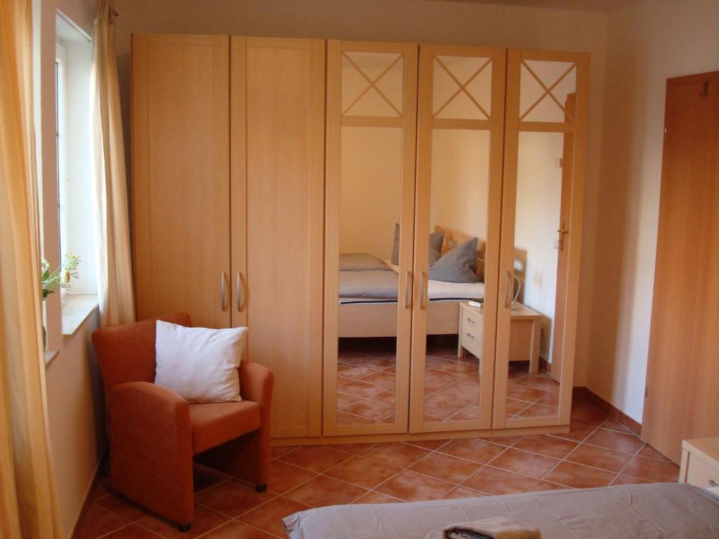 a bedroom with a closet with a bed and a chair at Godewind in Insel Poel