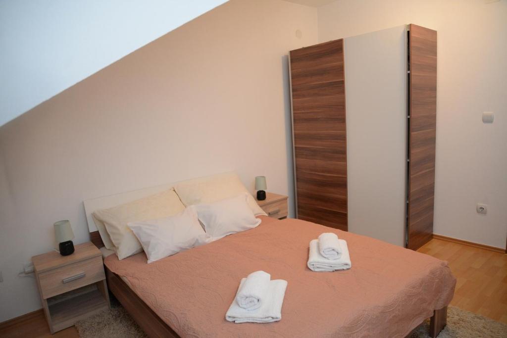 ein Schlafzimmer mit einem Bett mit zwei Handtüchern darauf in der Unterkunft Apartmani MARIN in Županja
