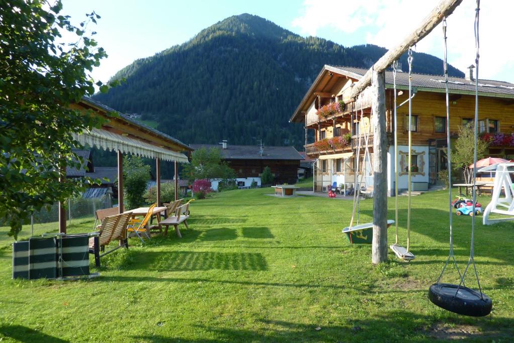 a yard with a house and a swing at Residence Bannwald in Valle Di Casies