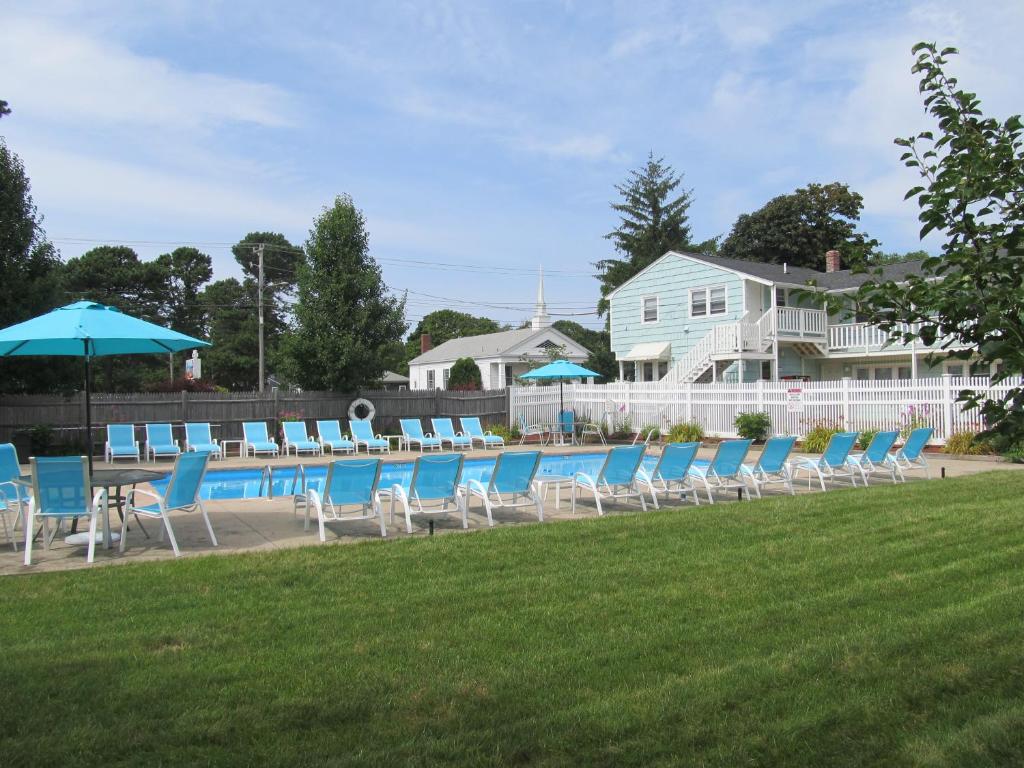 a group of chairs and umbrellas on a lawn at The Escape Inn in South Yarmouth