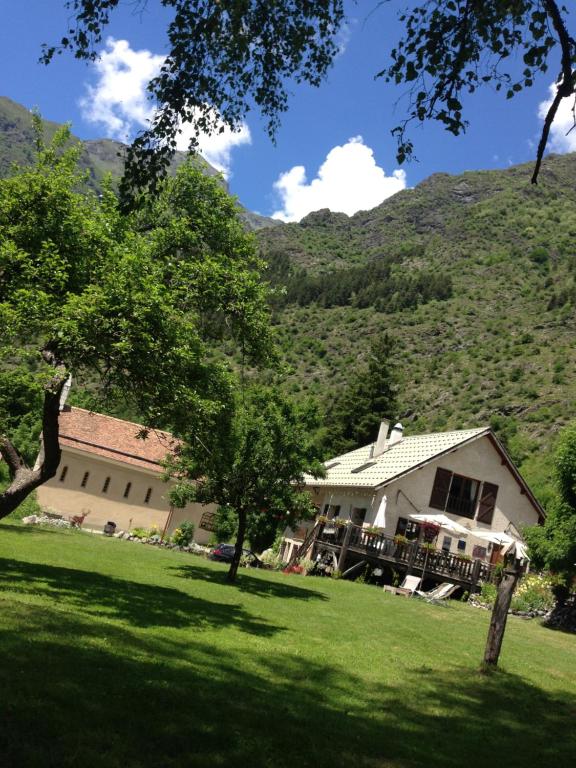 una casa en un campo con una montaña en el fondo en AUBERGE GAILLARD en La Motte-en-Champsaur