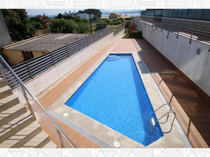 a swimming pool on the side of a building at Residencial Cabodeiro in Isla de Arosa