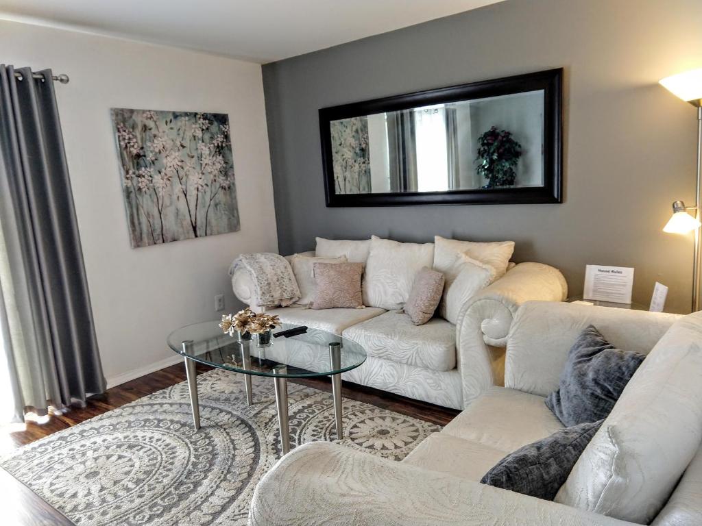a living room with a white couch and a glass table at Delightful Townhome - Central Raleigh Location in Raleigh