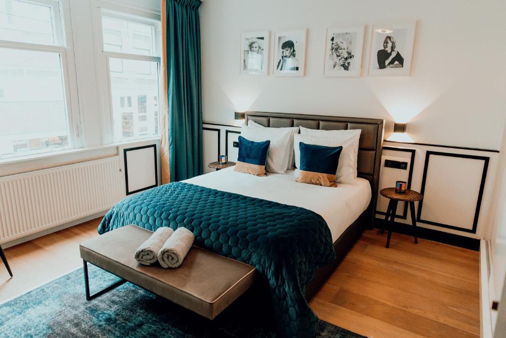 a bedroom with a large bed with a blue blanket at The Harlemstreet Suites in Amsterdam