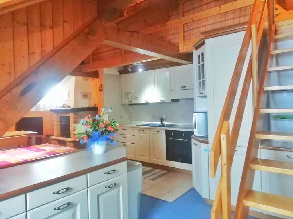 una cucina con armadietti bianchi e una scala di Casa Vacanza Tonale CIPAT -AT-25357uno a Passo del Tonale