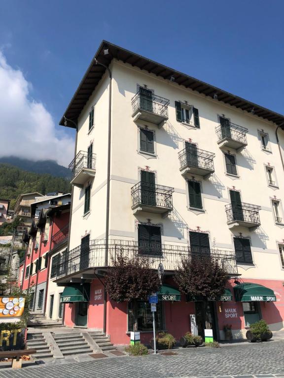 a large white building with balconies on a street at Residence Milcar in Chiesa in Valmalenco