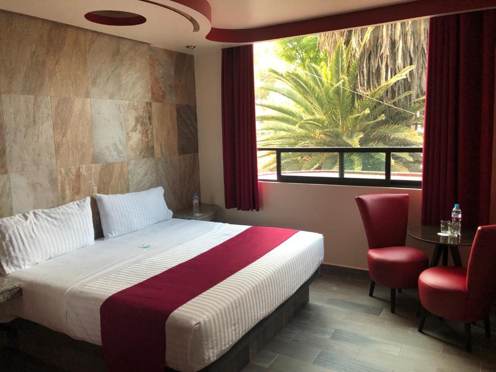 a bedroom with a bed and a window and a table at Hotel Jard Inn Adult Only in Mexico City