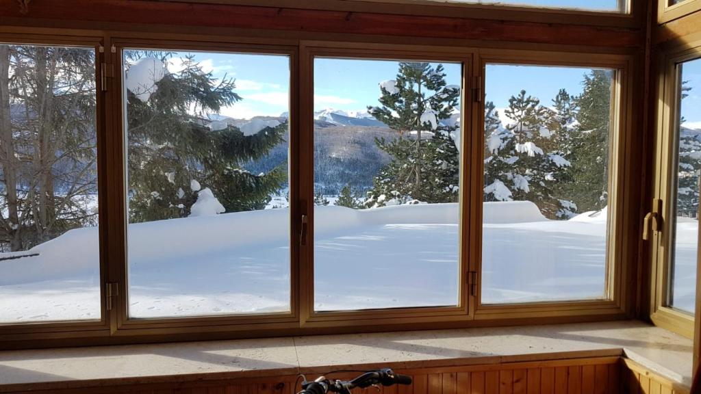 a window with a view of a snow covered mountain at Casa Nilù in Rivisondoli