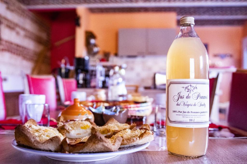 a bottle of orange juice next to a plate of food at B & B - Chambre d'hôte entre Arras et Albert in Souastre