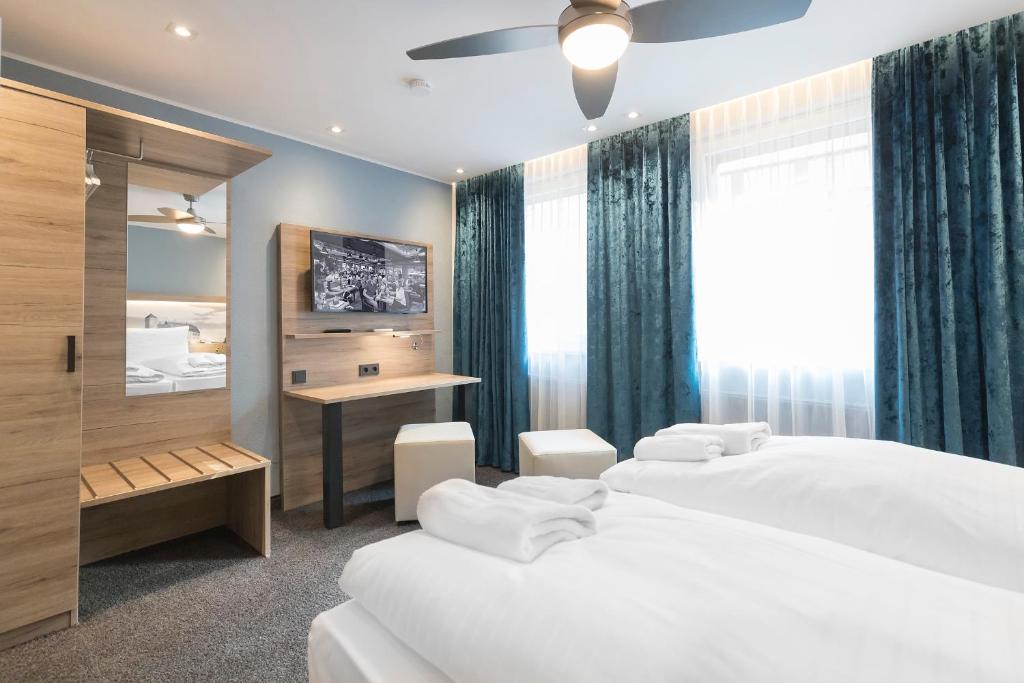 ein Hotelzimmer mit 2 Betten und einem Schreibtisch in der Unterkunft Hotel dasPaul in Nürnberg
