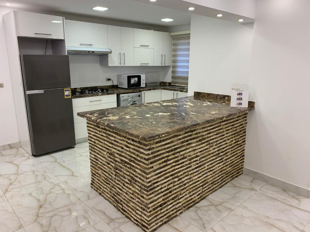 a kitchen with white cabinets and a granite counter top at Le Royal Residence 2 in Cairo
