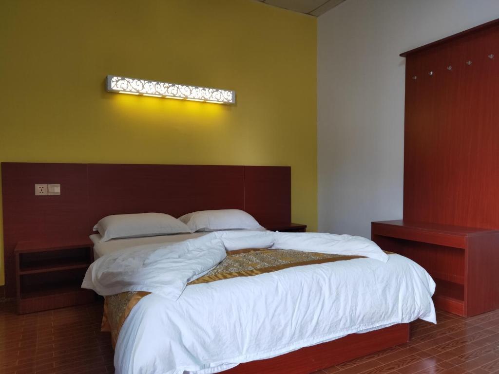 1 dormitorio con 1 cama grande con sábanas blancas en CHONG TI HOTEL, en Dili