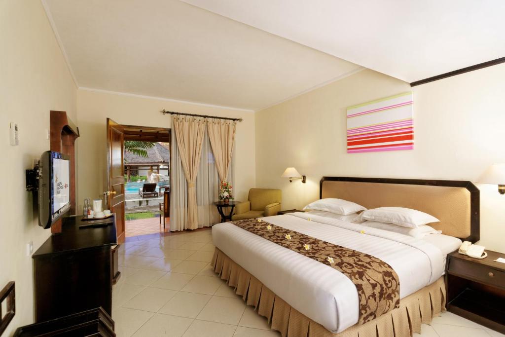 Postel nebo postele na pokoji v ubytování Legian Paradiso Hotel